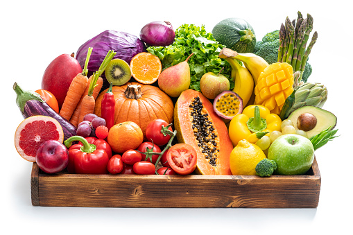 Assorted vegetables and fruits in wooden crate box isolated on white background