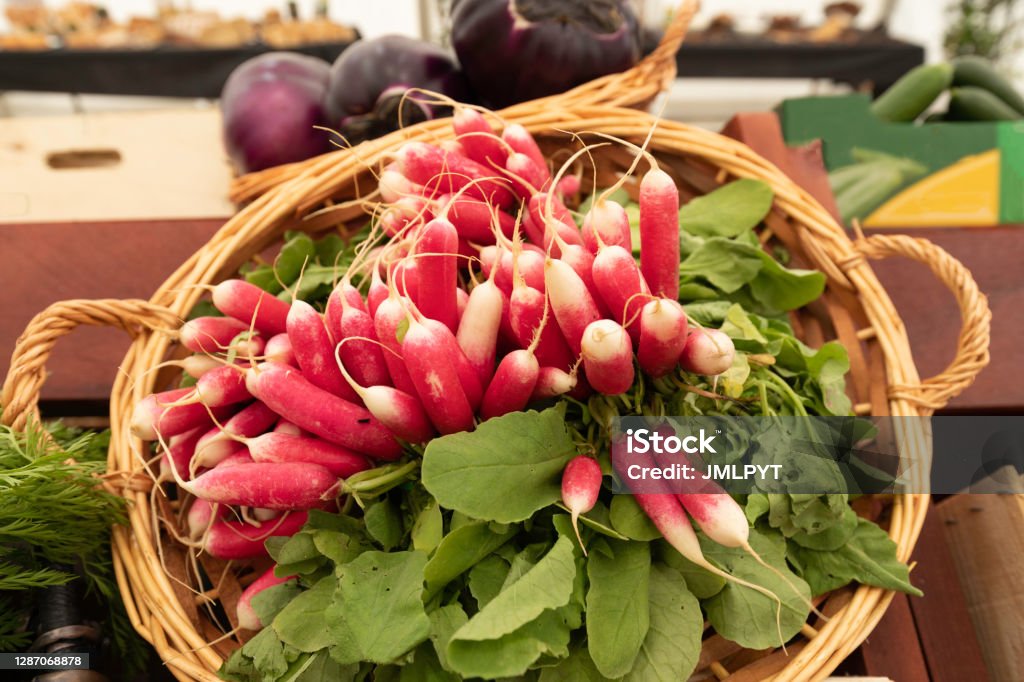 Radishes in a basket on a market stall Market stall, selective shot, focus on foreground Close-up Stock Photo
