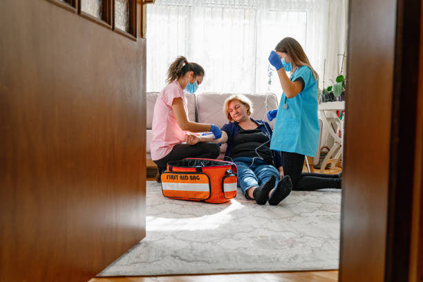 Paramedics give first aid to an unconscious elderly woman