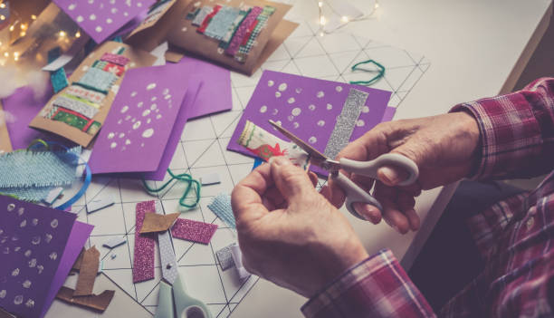 Senior man creating Christmas Cards at home