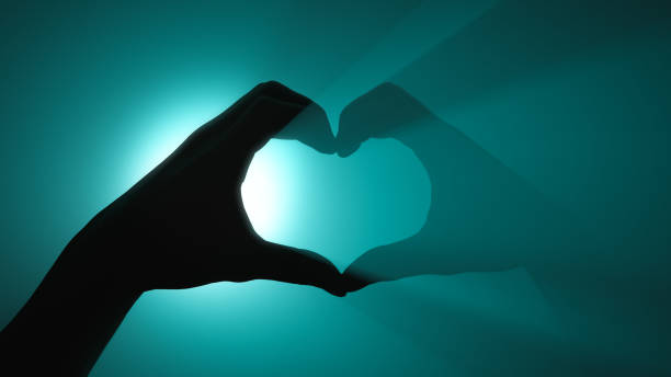 istock Heart shape. Hand gesture. Turquoise spotlight in background 1287070213