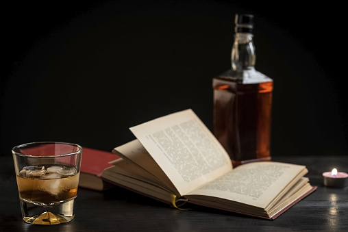 a glass of whiskey and a good book - time to relax - photo in retro style