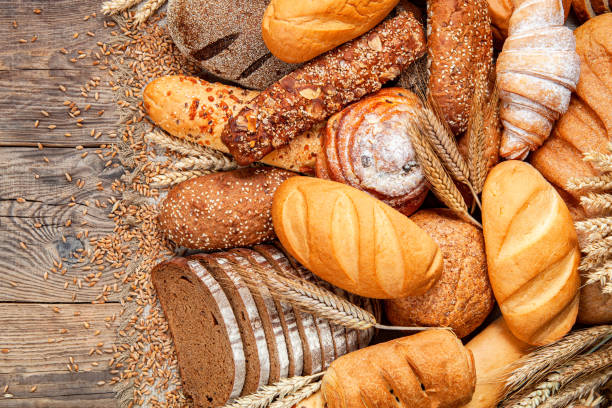 istock Assortment of baked bread on wooden table background 1287074792