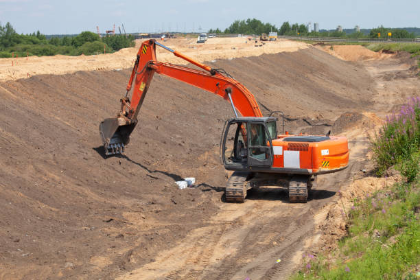 istock orange excavator works on road construction. 1287074840