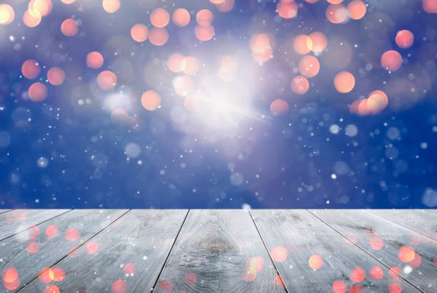 istock Abstract Snowy Christmas Background. Wooden Table With Defocused Lights 1287079287