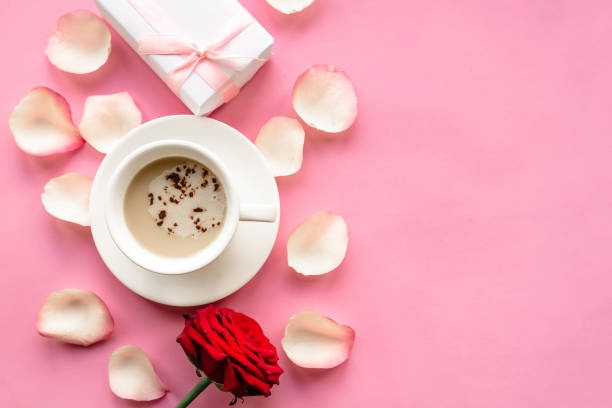 istock Coffee cup and rose on pink background, top view. Valentines Day background, copy space 1287081258