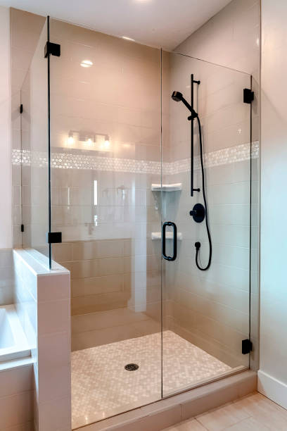 istock Shower stall with half glass enclosure and black shower head and handle 1287081404