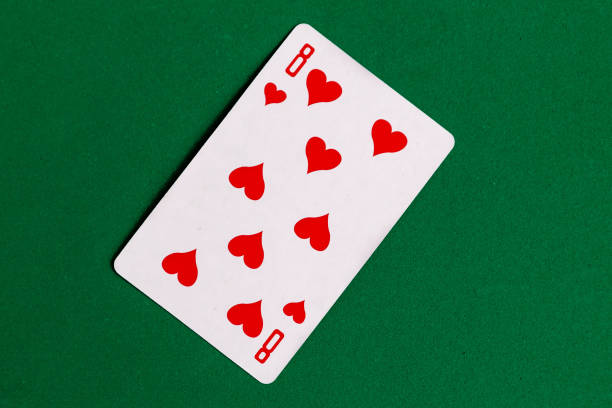 istock Eight of Hearts playing card, green background. 1287081988