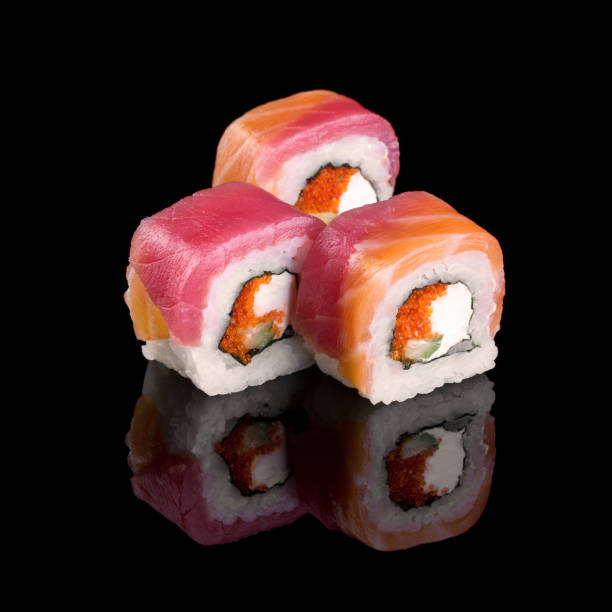 istock Sushi with cheese philadelphia and tobiko on a black background with reflection. 1287082218