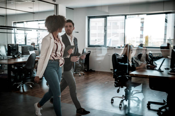 istock Business colleagues walking through the office 1287084821