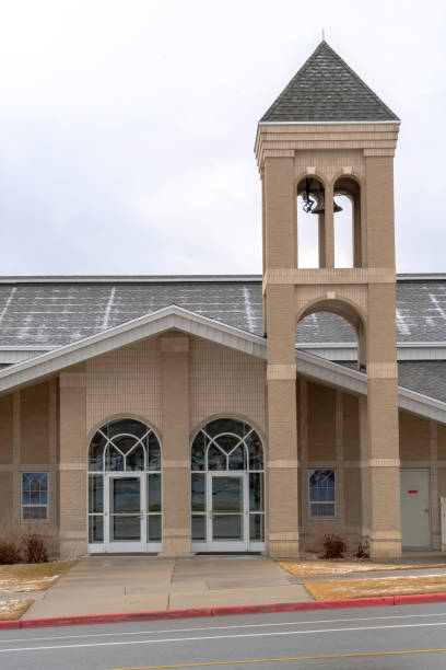 istock Church facade with glass front doors and modern belfry tower against cloudy sky 1287084911