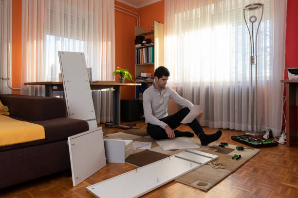 istock Young man reading the instructions to assemble furniture 1287086885