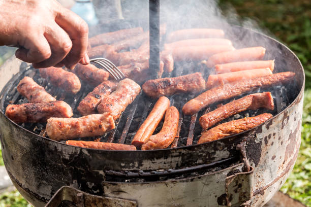 istock Sausages on smoking Barbecue Grill in garden or backyard 1287088416
