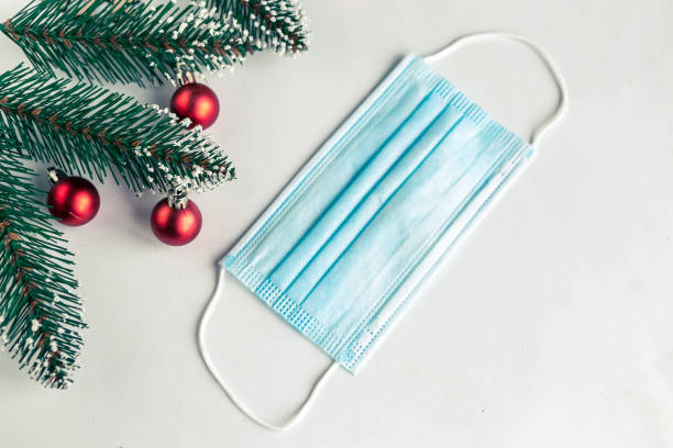 istock christmas tree branches and face mask on white background, coronavirus Christmas concept 1287089190