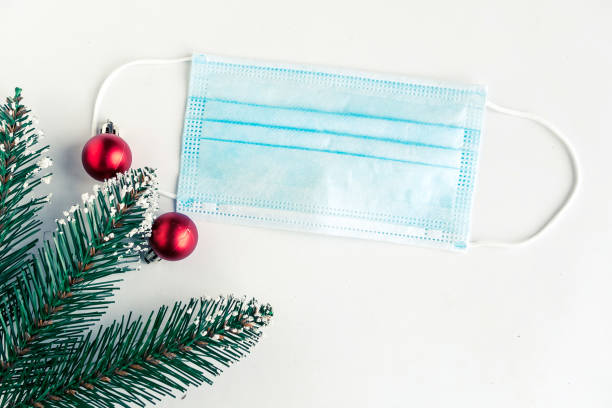 istock christmas tree branches and face mask on white background, coronavirus Christmas concept 1287089201