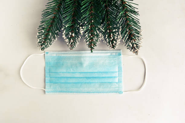 istock christmas tree branches and face mask on white background, coronavirus Christmas concept 1287089224