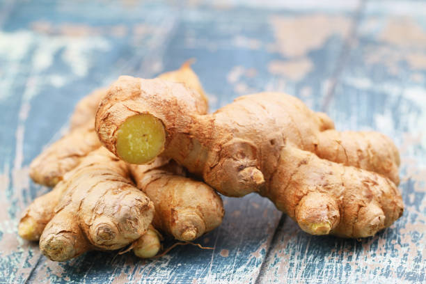 istock Closeup of fresh root of ginger on blue rustic wooden surface 1287090534