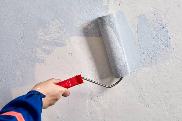 istock Coloring walls at home using paint roller by repairman. 1287092161