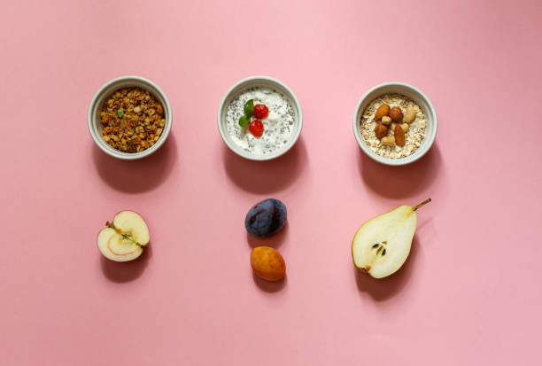 istock healthy Breakfast set with granola, oatmeal, yogurt and fruit. Layout on a pink background horizontally 1287092218