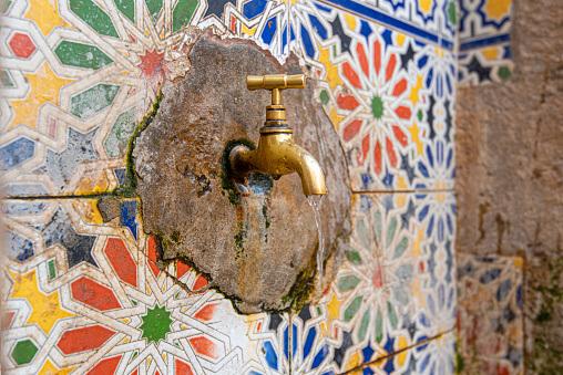 Copper faucet with drinking water on a street in medina, Morocco