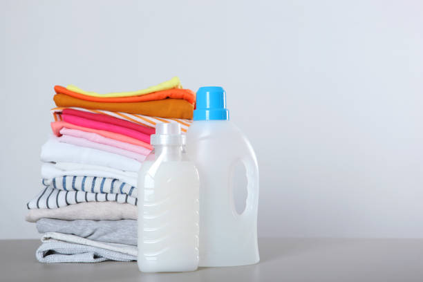 istock Laundry detergent bottles and clothes on the table. Household chemicals 1287093557