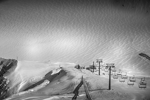 Empty ski lift in winter ski resort - Holidays. Winter landscape of mountain covered of snow in black and white. Glaciers 3000, Diablerets, Switzerland. Tranquility.