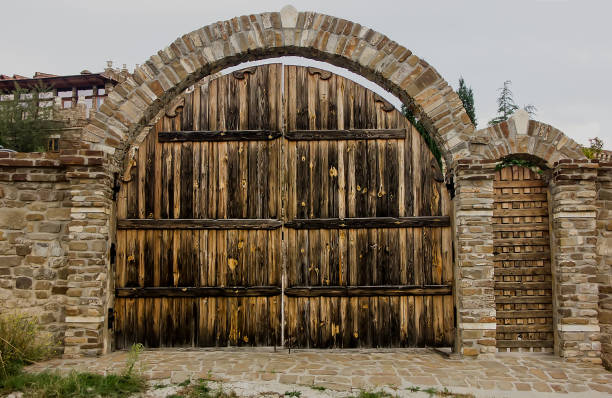 Large Wooden Gate Framed With Natural Stone In The Form Of An Arch Detail