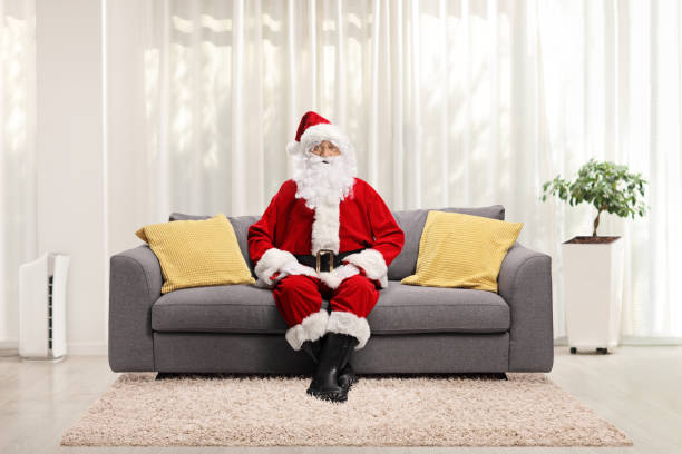 istock Santa claus resting on a gray sofa at home 1287095634
