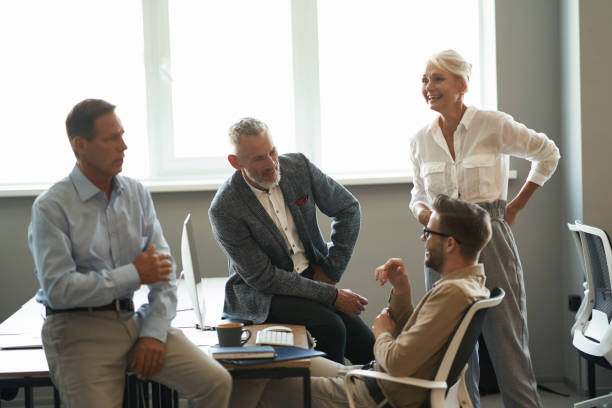 istock Group of happy multiracial colleagues talking and smiling, discussing something while working together in the modern office 1287096320