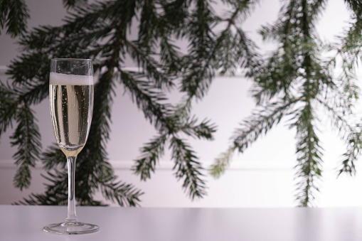 a glass of champagne stands on the New Year's table on a white background