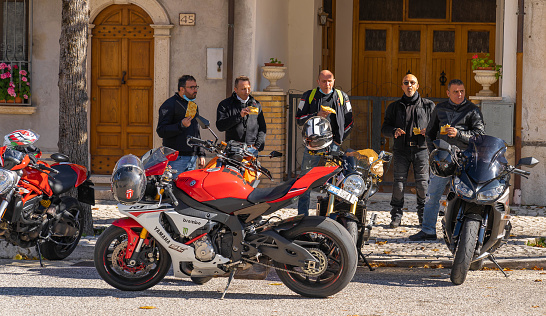 Orvinio, Italy - October 31, 2020, Masked and unmasked traveling bikers who stop to eat in Italian Borgo Orvinio during second wave of coronavirus (Covid19), non-observance of social distance in Italy