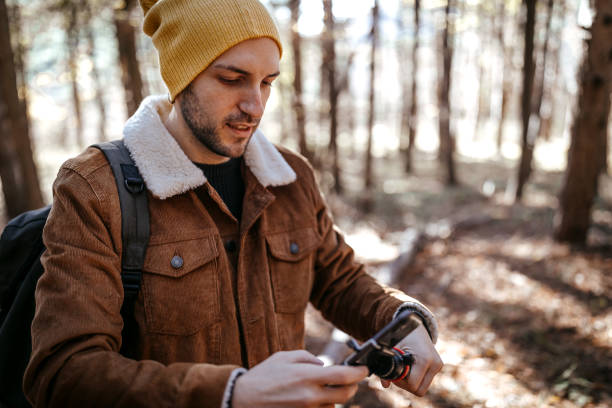istock Young man preparing to record video for vlog on beautiful day on mountain 1287101368