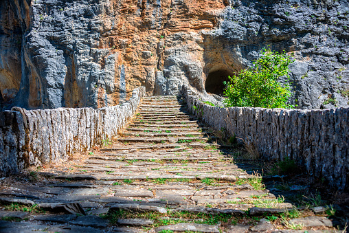 Vikos Gorge/ Greece July 25, 2019: The Noutsou bridge (or Kokkori, as it is also known), a single arch stone bridge, is located in central Zagori, between the villages of Koukouli, Dilofo and Kipoi