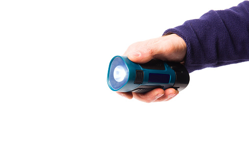 Portable flashlight in a man's hand on a white background