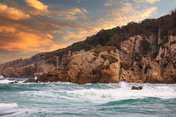 istock Sunrise with Rock formation and waves at beach 1287103901
