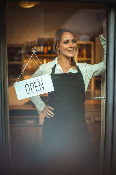 istock Smiling women and sign ''open'' 1287104511