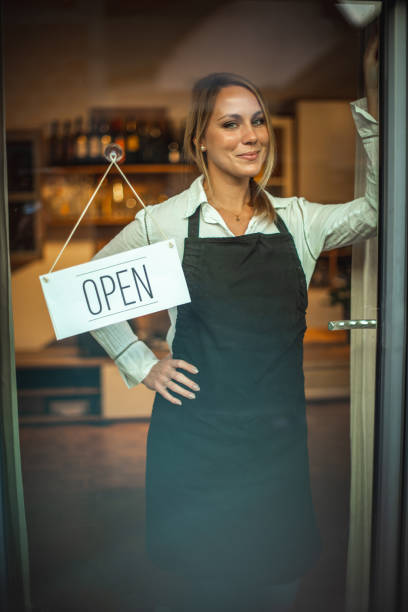 istock Smiling women and sign ''open'' 1287105323