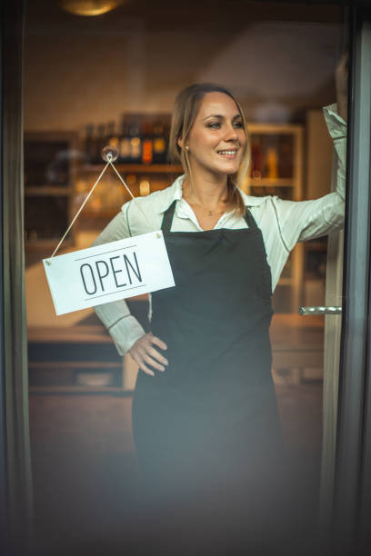 istock Smiling women and sign ''open'' 1287105394