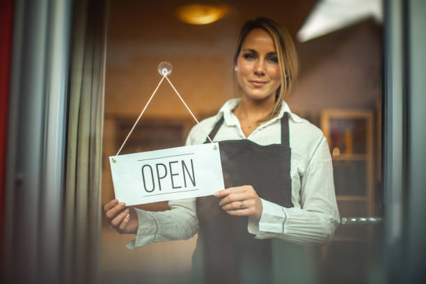 istock Smiling women and sign ''open'' 1287105675