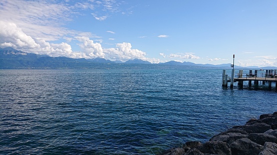 Lausanne, Switzerland. Different blue colors of Lake Geneva, surrounding mountains, and sky.