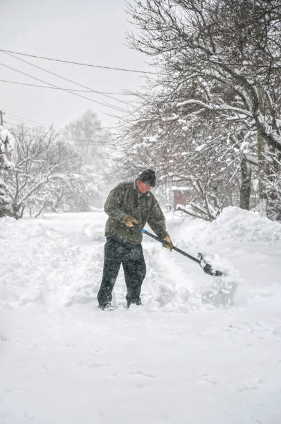 istock Man with a shovel cleans the track from the snow 1287109040