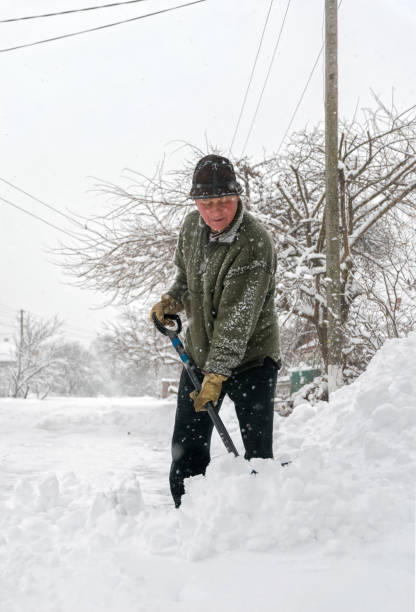 istock Man with a shovel cleans the track from the snow 1287109099