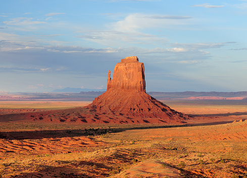 View To The West Mitten Butte In The Monument Valley Arizona In The Late Afternoon Sun On A Sunny Summer Day With A Clear Blue Sky And A Few Clouds