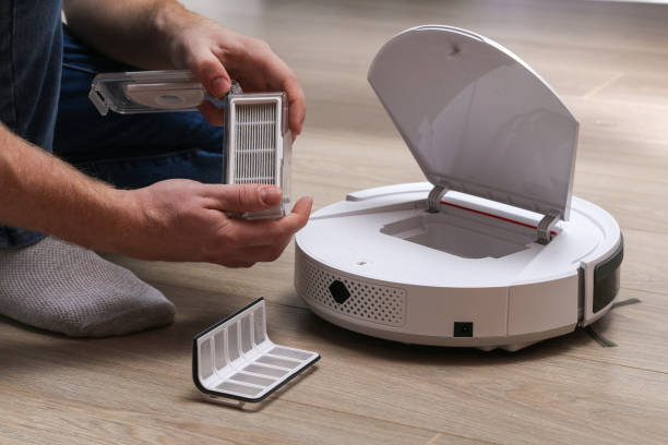 istock A man inserts a filter and a container to collect dust and debris into robot vacuum cleaner. 1287113171