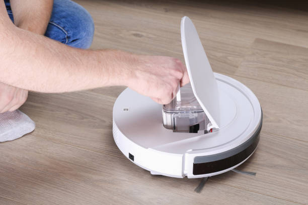 istock A man inserts a filter and a container to collect dust and debris into robot vacuum cleaner. 1287113172