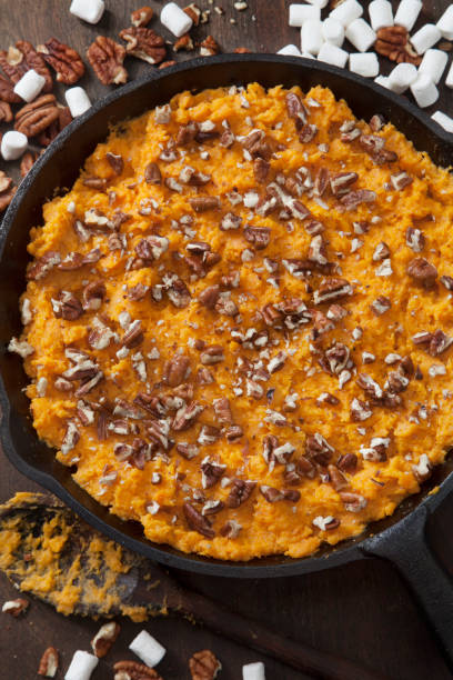 Preparing Sweet Potato Casserole with Pecans and Marshmallows