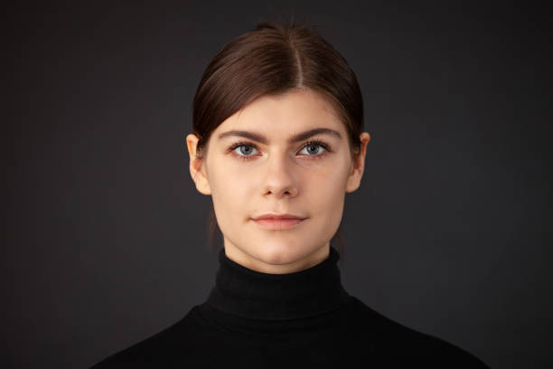 Studio portrait of 20 year old woman Close up studio portrait of 20 year old woman with brown ponytail hair in a black sweater on a black background gray eyes photos stock pictures, royalty-free photos & images