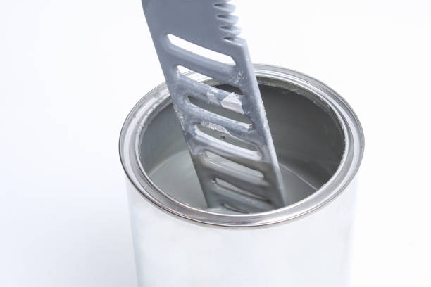 istock A man stirring white paint in can on white background. Renovation concept. 1287116157