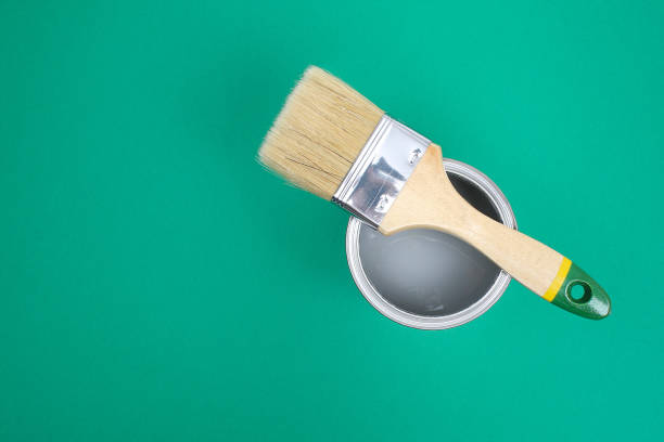istock Open paint enamel cans on green turquoise palette samples. 1287116169