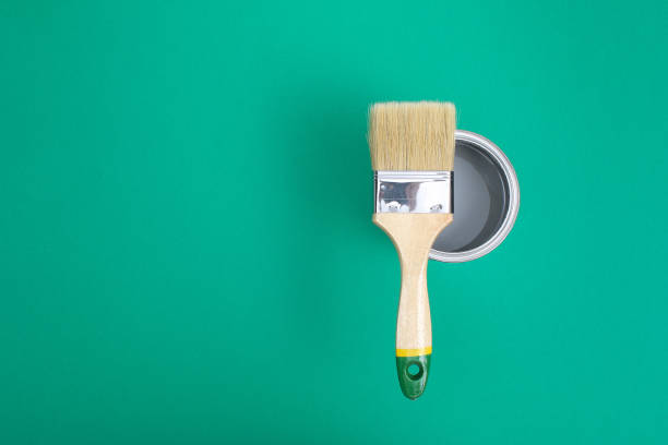 istock Open paint enamel cans on green turquoise palette samples. 1287116175